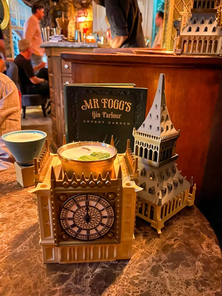 cocktail served inside an elizabeth tower replica at mr foggs gin parlour in london