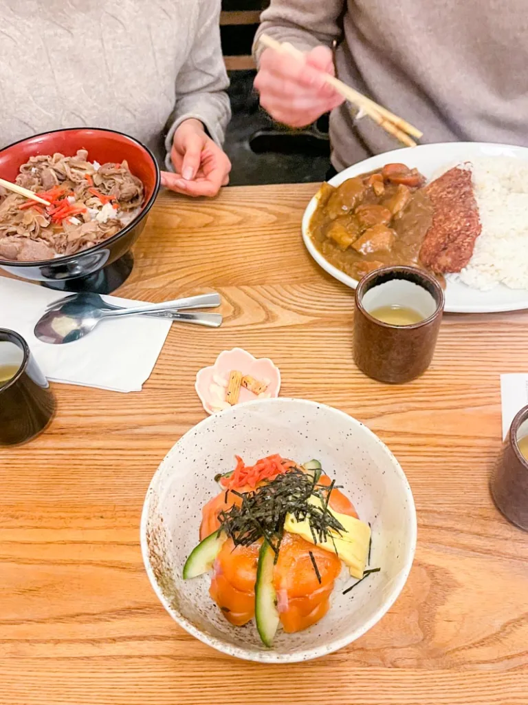 a salmon bowl, a gyudon bowl, and a plate of japanese curry at tokyo diner, one of the best eats in london